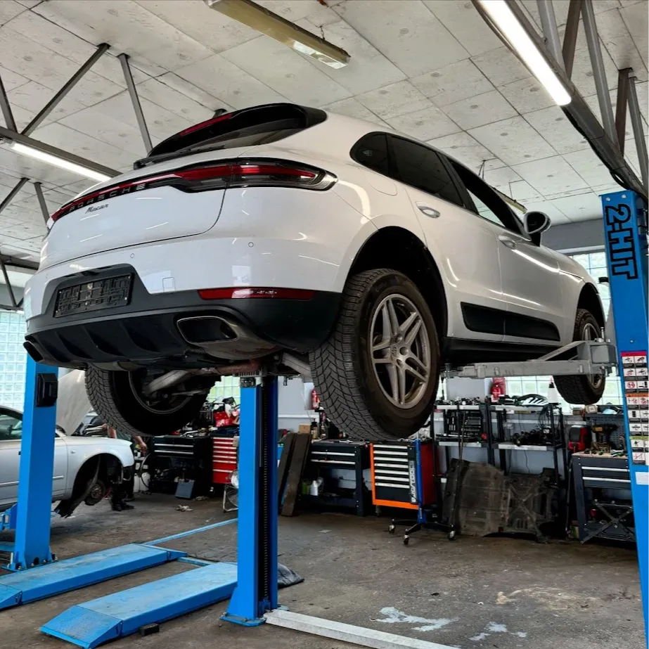 Biały samochód na podnośniku w warsztacie Twin Torque Service